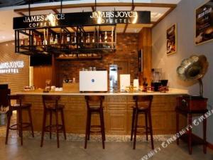 a bar in a restaurant with bar stools at James Joyce Coffetel Tianjin Development 3rd Street MSD in Binhai