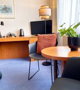a room with a table and a chair and a desk at Garni Hotel Gartenstadt Erfurt in Erfurt