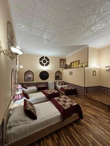 um quarto com quatro camas com um tecto pintado com um carro em Karavansaray Xurjin Old em Bukhara