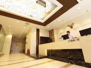 een man aan een balie in een hotellobby bij PAI Hotel·Changchun Jilin DaLu in Changchun