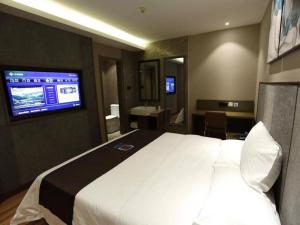 Habitación de hotel con cama blanca grande y escritorio. en PAI Hotel·Changchun Jilin DaLu, en Changchún