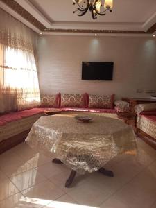 ein Wohnzimmer mit einem Tisch und einem Sofa in der Unterkunft Dari A10 in Agadir