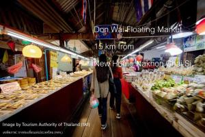 deux personnes marchant à travers un marché où la nourriture est présentée dans l'établissement New Home Nakhon Chai Si, à Talat Amphoe Nakhon Chai Si