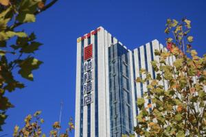wysoki budynek z znakiem na boku w obiekcie Echeng Hotel Dongying Kenli Destrict Government w mieście Kenli