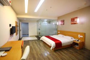 a bedroom with a bed and a glass shower at Thank Inn Plus Hotel Zhuhai Nanping pedestrian Street Huafa shopping Center in Nanping