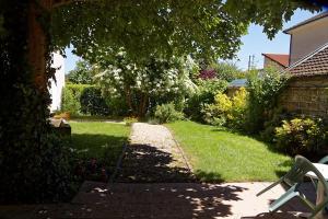 a garden with a path leading to a house at Hotel Au Bon Sejour in Vitry-le-François