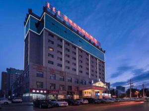 Vienna Hotel Tongliao Ke'erqin في تونغلياو: مبنى الفندق يوجد عليه لافته