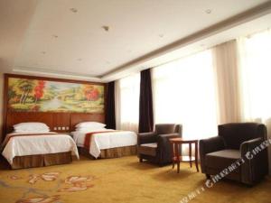 Vienna Hotel Tongliao Ke'erqin في تونغلياو: غرفة فندقية بسريرين و كرسيين
