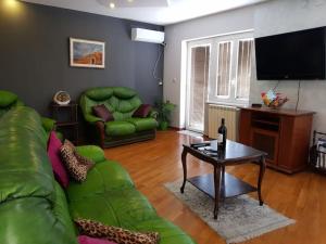uma sala de estar com um sofá verde e uma mesa em 200 m2 Centre Penthouse Amazing Balcony em Belgrado