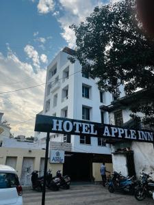 アーメダバードにあるHotel Apple Innの建物の前にオートバイを停めたホテル