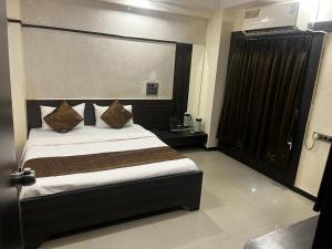 a bedroom with a large bed in a room at Hotel Apple Inn in Ahmedabad