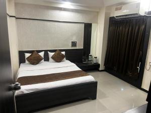 a bedroom with a large bed in a room at Hotel Apple Inn in Ahmedabad