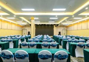 a room with green and white chairs and tables at Echarm Hotel Guiyang Longdongbao International Airport Outlets in Guiyang