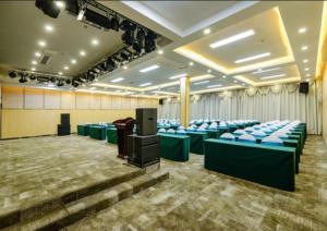 uma sala de conferências com cadeiras azuis e um pódio em Echarm Hotel Guiyang Longdongbao International Airport Outlets em Guiyang