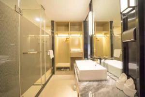 ein Bad mit einem Waschbecken und einer Dusche in der Unterkunft Echarm Hotel Fuzhou Yantai Mountain Olympic in Cangqian