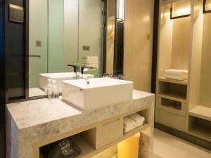 a bathroom with a sink and a large mirror at Echarm Hotel Changchun Yiqi Automotive Trade City Wanda in Changchun