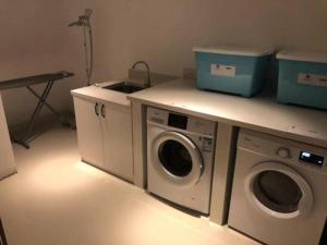 eine Waschküche mit einem Waschbecken und einer Waschmaschine in der Unterkunft Echarm Hotel Changchun Yiqi Automotive Trade City Wanda in Changchun