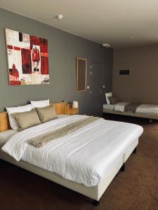 sypialnia z dużym białym łóżkiem w pokoju w obiekcie HOTEL BORNEM w mieście Bornem