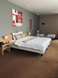 - une chambre avec un grand lit blanc dans l'établissement HOTEL BORNEM, à Bornem