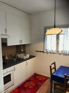 eine Küche mit weißen Schränken und einem blauen Tisch in der Unterkunft mini Haus mit Pergola -NL-00000196 in Tenero