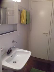 ein Badezimmer mit einem weißen Waschbecken und einem Spiegel in der Unterkunft mini Haus mit Pergola -NL-00000196 in Tenero
