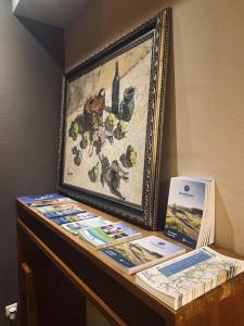 a table with a picture and books on it at HOTEL BORNEM in Bornem