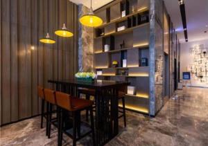 a dining room with a table and some yellow lights at Echarm Hotel Aegean Shopping Park Zhonghuan Plaza in Tangshan