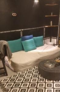 1 cama con almohadas azules y verdes en una habitación en G - House en Dahab
