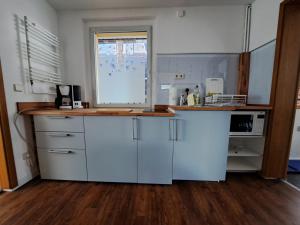 eine Küche mit weißen Schränken und einem Fenster in der Unterkunft 3 Sterne FH Fürstenwalde in Fürstenwalde
