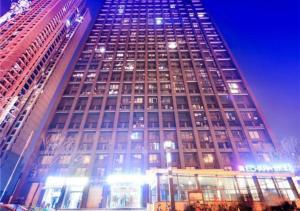 a tall building with many windows at night at Echarm Hotel Wuhan Huangpu Erqi Xiaolu Metro Station in Jiang'an