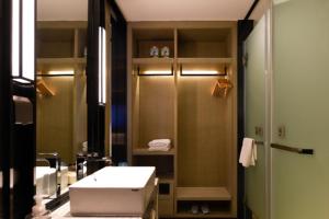 a bathroom with a sink and a shower at Echarm Hotel Huaihua Vocational College in Huaihua