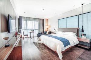 sypialnia z dużym łóżkiem i salonem w obiekcie Echarm Hotel Changde Chaoyang D5 District w Changde