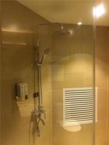 y baño con ducha y puerta de cristal. en City Comfort Inn Yi'Ning Jichang Road Shanghaicheng, en Kipekyüzi