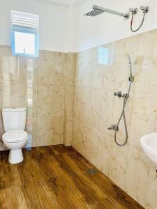 uma casa de banho com um chuveiro, um WC e um lavatório. em Villa Yoshan em Ambalangoda
