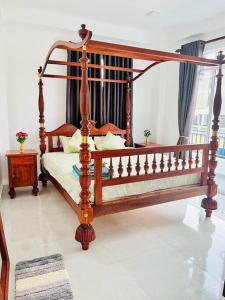 uma cama de dossel em madeira num quarto com em Villa Yoshan em Ambalangoda