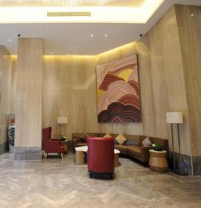 a lobby with a couch and a painting on the wall at Echeng Hotel Beihai Hunan Road Old Street in Gaode