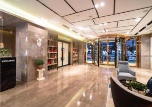a large room with a lobby with a couch and chairs at Echarm Hotel Zunyi Conference Site Gang'ao Branch in Zunyi