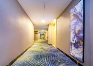 a hallway with a painting on the wall at Echarm Hotel Zunyi Conference Site Gang'ao Branch in Zunyi