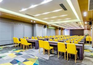 a conference room with a long table and yellow chairs at Echarm Hotel Zunyi Conference Site Gang'ao Branch in Zunyi