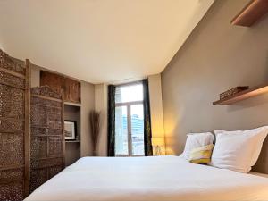 a bedroom with a large white bed with a window at Appartements en Centre Ville de Bordeaux in Bordeaux