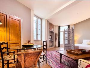 a living room with a table and chairs and a bed at Appartements en Centre Ville de Bordeaux in Bordeaux