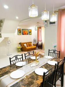 a dining room with a table and chairs and a couch at Bale de Barbara in Pampang