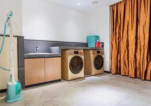 a kitchen with two washing machines and a sink at Echarm Hotel Heze Renmin Road Peony Garden Railway Station in Heze