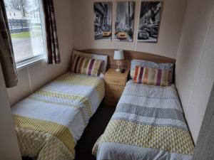 two twin beds in a small room with a window at Tattershall Lakes, Castle View in Tattershall