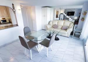 een woonkamer met een bank en een tafel en stoelen bij Skol 727 Lovely 2 Bedroom Duplex in Marbella Center in Marbella