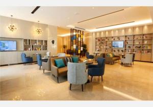 a lobby of a hotel with chairs and tables at Echarm Hotel Liuzhou Liunan Wanda Plaza in Liuzhou