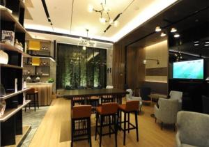 um quarto com um bar com cadeiras e uma televisão em Echarm Hotel Guilin High-tech Wanda Li Lake em Guilin