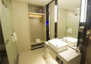 a bathroom with a sink and a mirror at Echarm Hotel Beihai Yintan in Dianbailiao