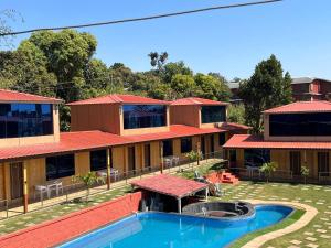 a house with a swimming pool in front of it at Arya's Village in Mahabaleshwar