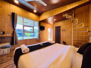 a bedroom with a large bed in a room with wooden walls at Arya's Village in Mahabaleshwar